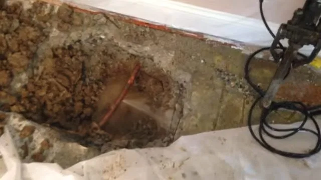 Acoustic leak-detection sensor placed against a brick floor to trace an underground line