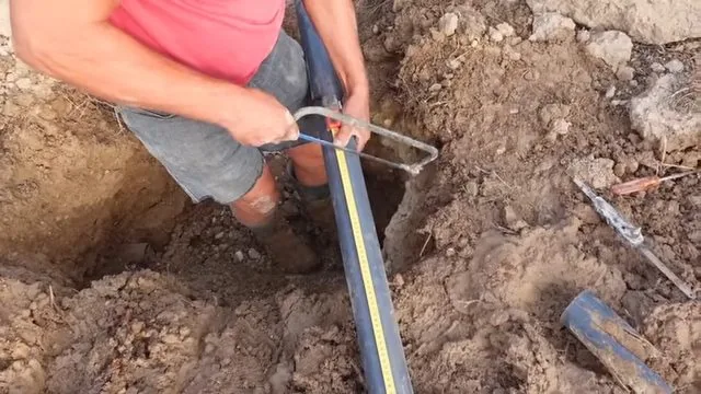 Repaired sewer line section being aligned inside an open trench