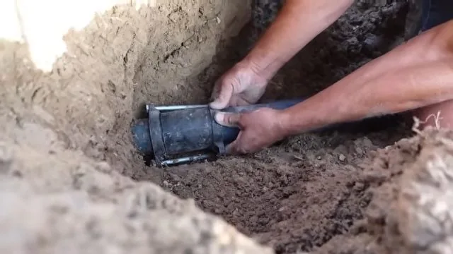 Repair sleeve being aligned over a section of damaged water pipe