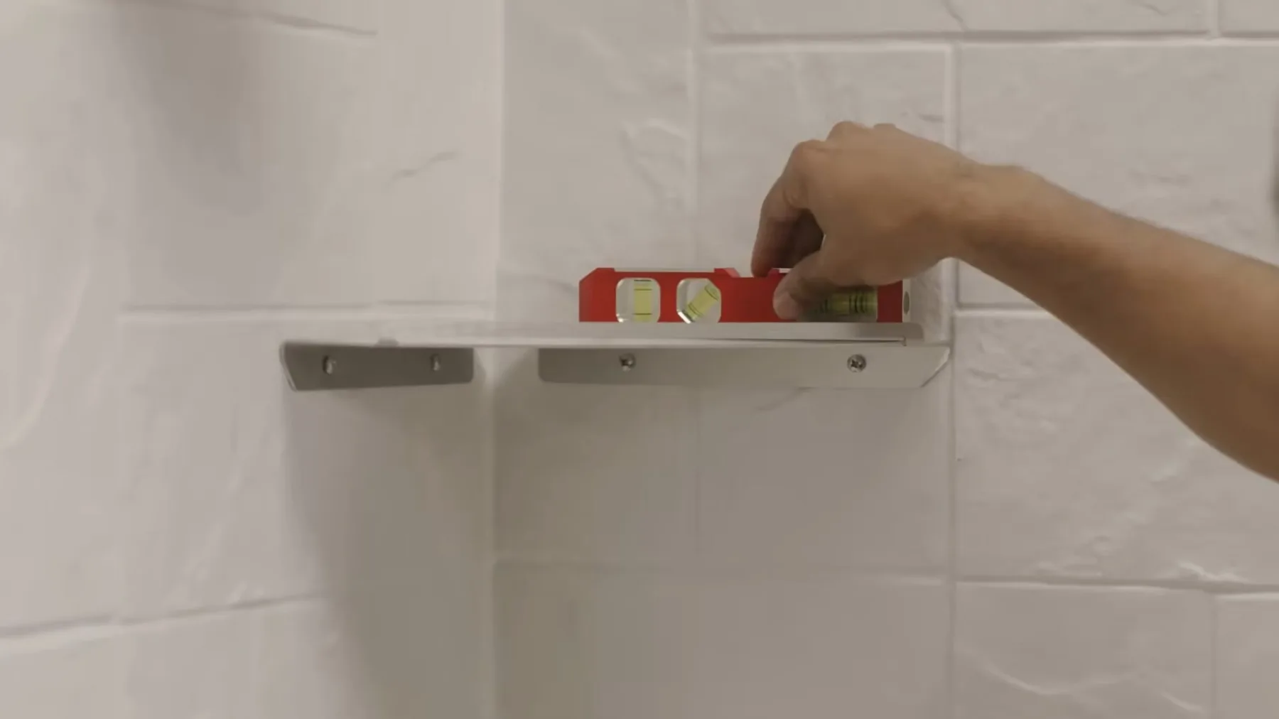 Wall fixture being leveled during a bathroom remodel