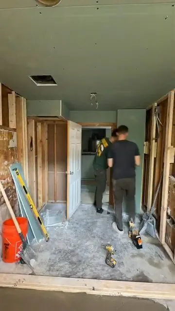 Bathroom renovation with wall studs exposed for plumbing access