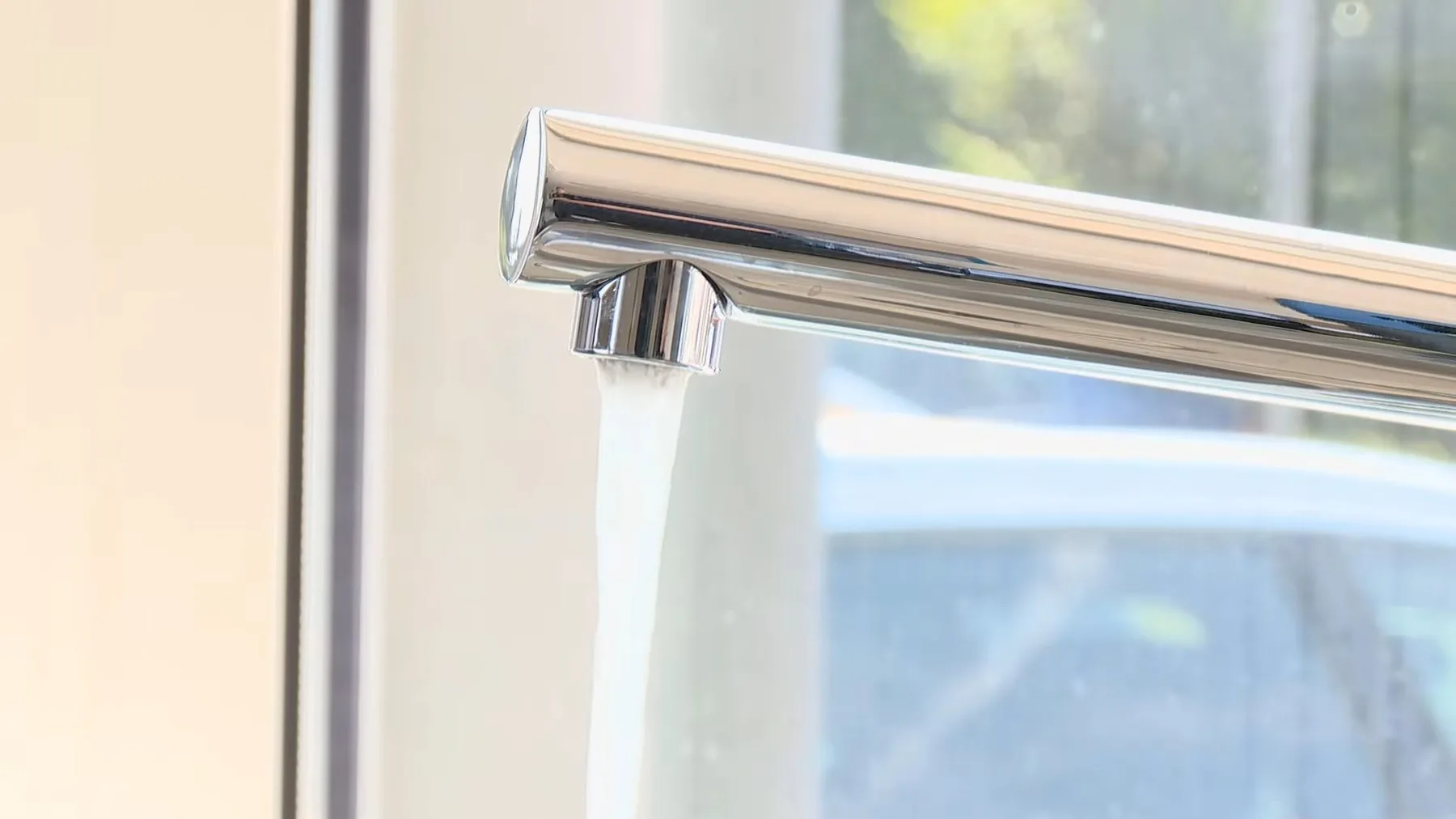Chrome kitchen faucet installed beside a window