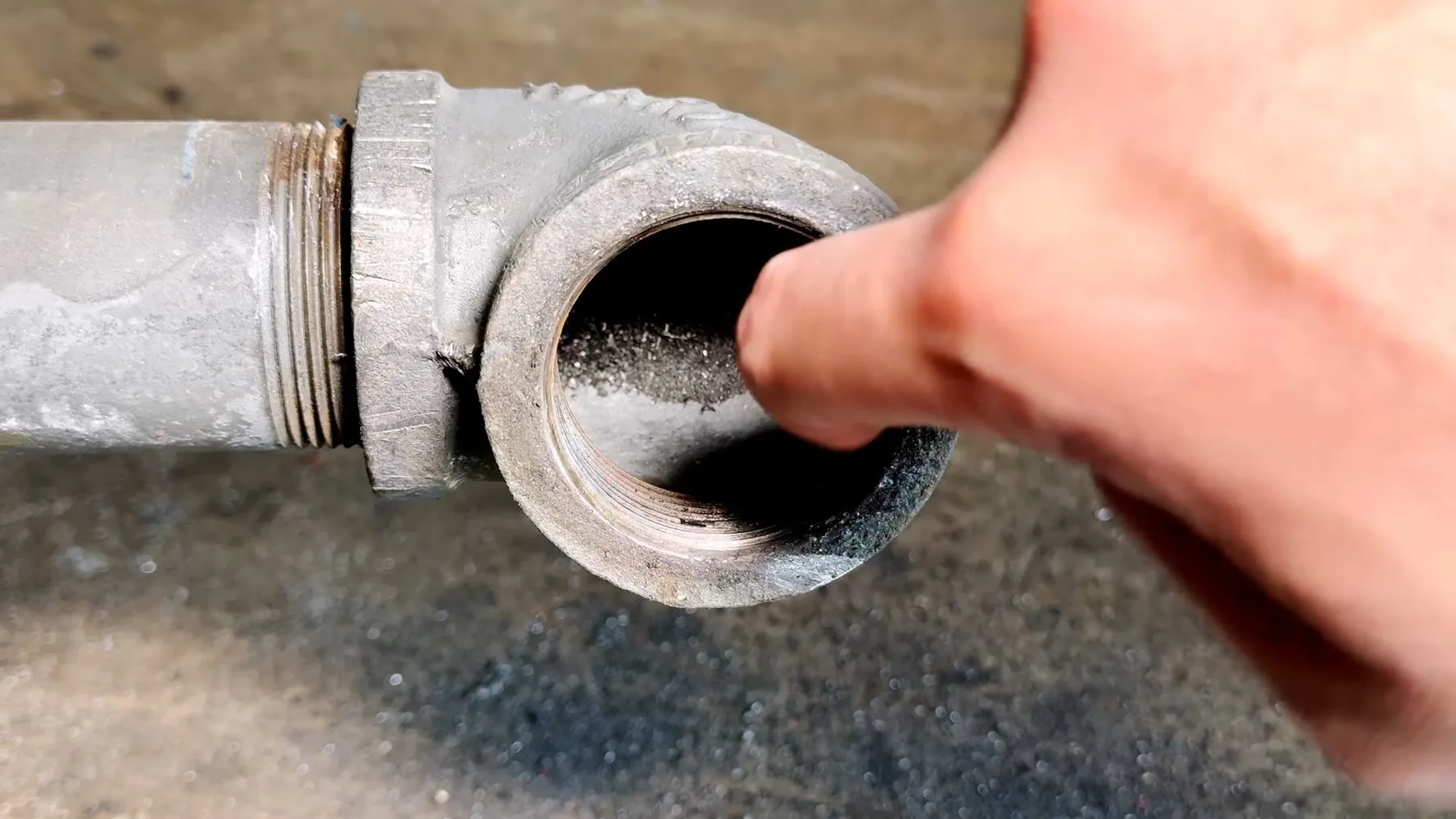 Close-up of an old cast iron cleanout opening showing its condition
