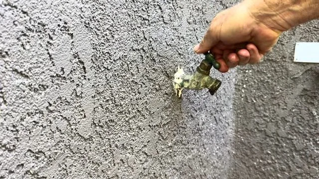 Outdoor faucet being closed after a repair to confirm it holds