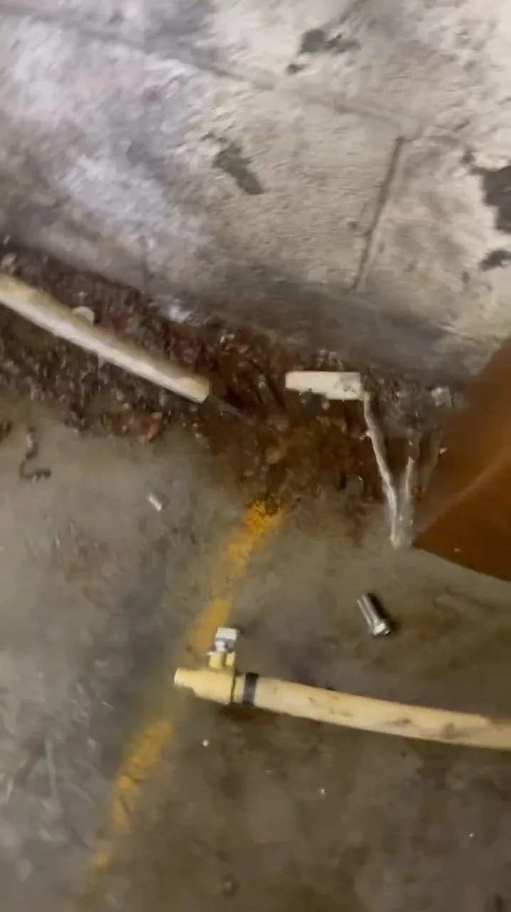 Copper pipe repair being made in a shallow floor trench