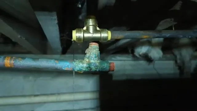 Frozen copper pipe being cut near a building foundation