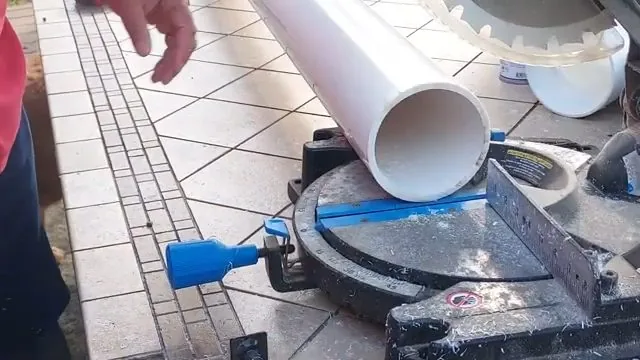 White PVC pipe being cut to length on a workbench