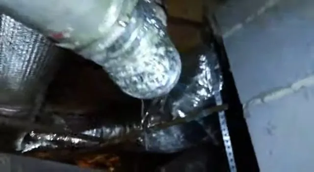 Close-up of a damaged metal pipe found inside a crawlspace