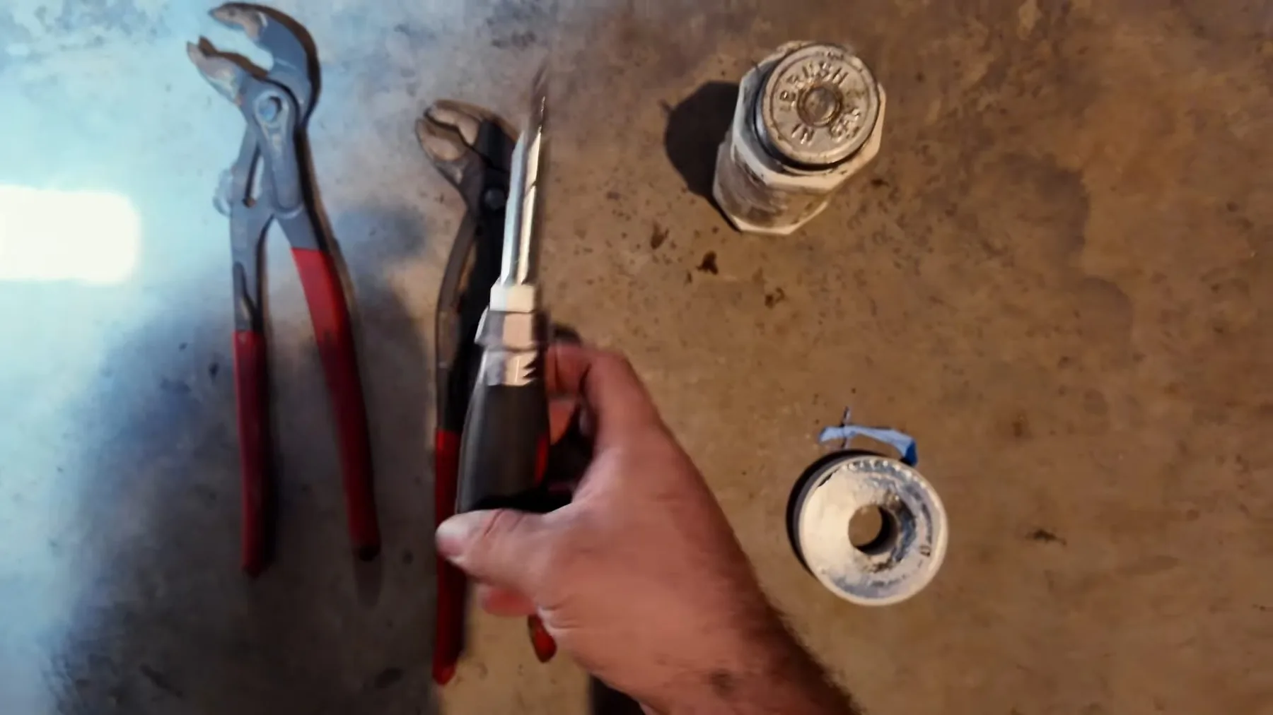 Old gas hose being disconnected from a water heater before replacement