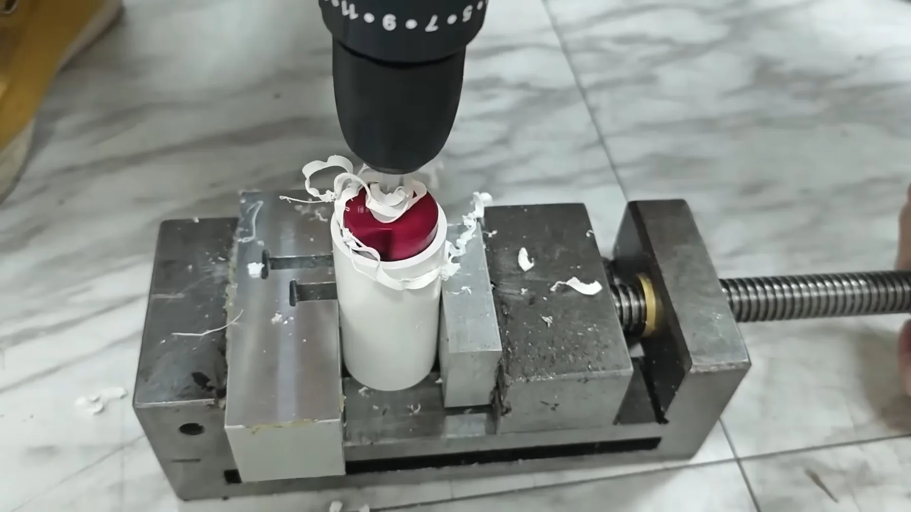 Drill press being used to prepare a plumbing fitting