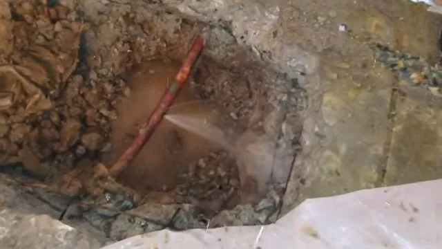 Indoor floor excavated to expose an underground water line