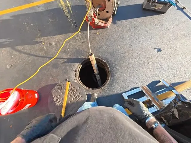 Drain snake being fed into a commercial restaurant floor drain