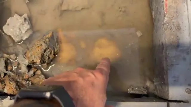 Technician pointing to the exact location of a slab leak in a concrete floor