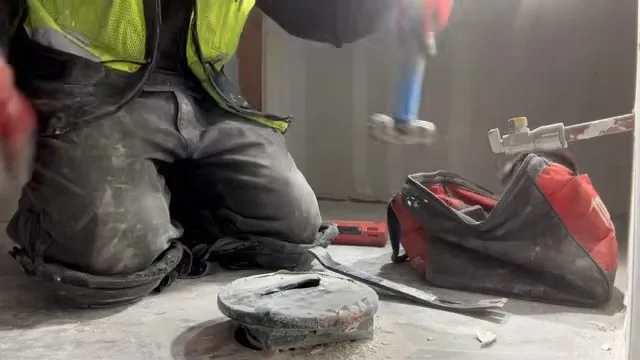 Commercial toilet flange being heated as part of a repair