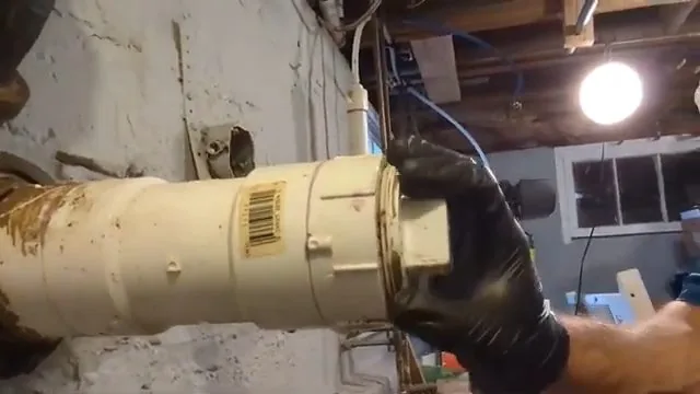 Home inspector opening a sewer cleanout cap ahead of a camera inspection