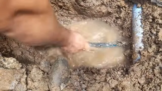 Muddy ground surrounding the site of a burst underground water line