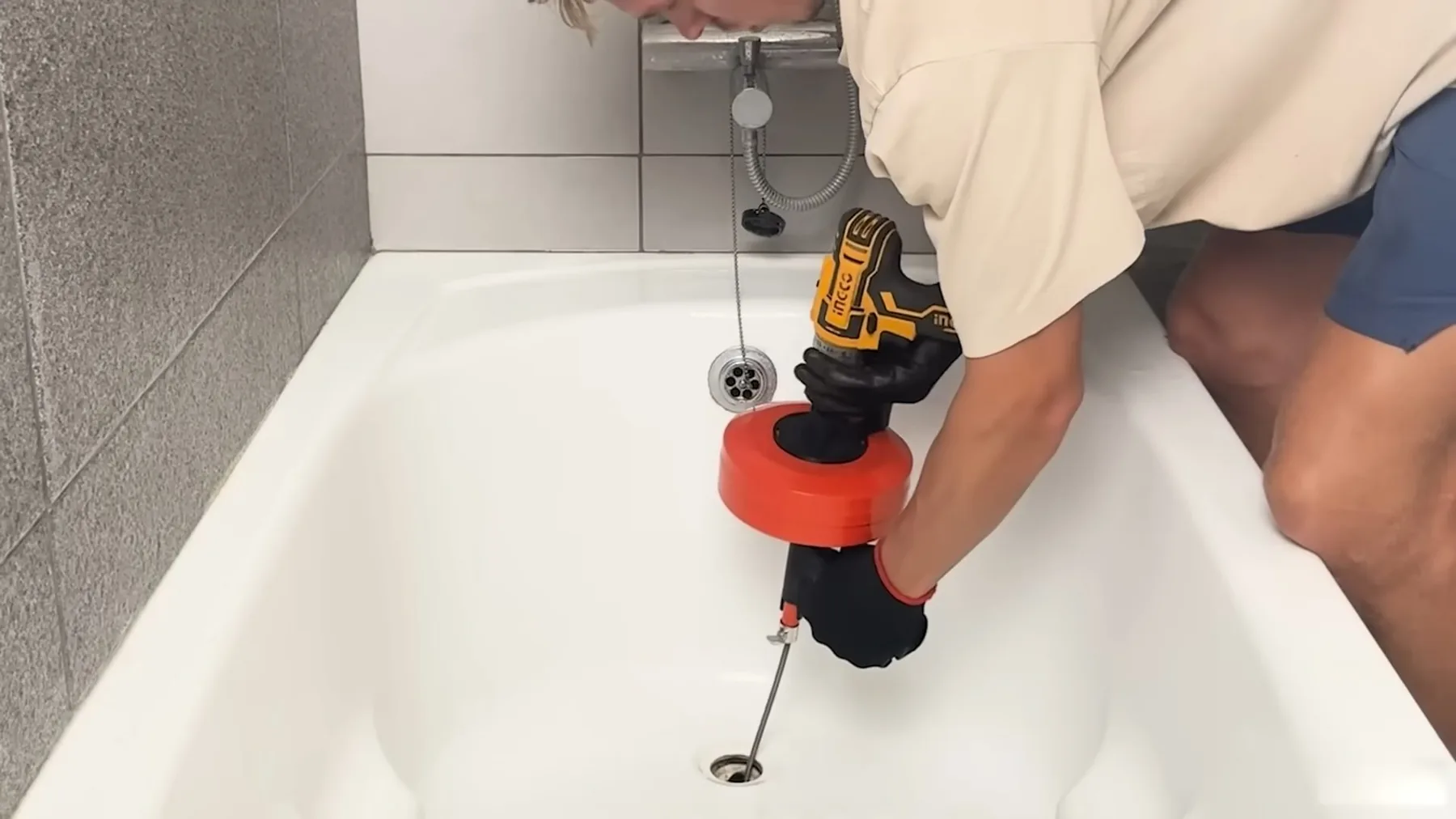Power drill being used on a bathtub drain during repair work