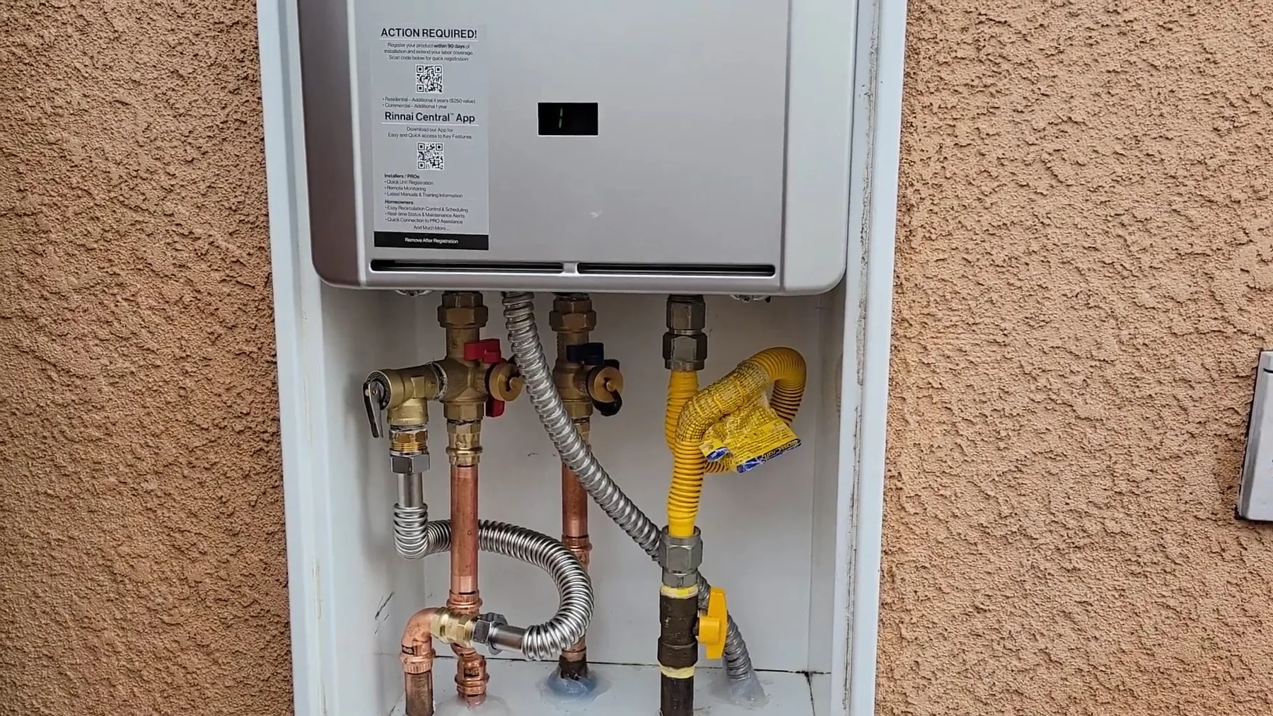 Tankless water heater mounted on an exterior stucco wall