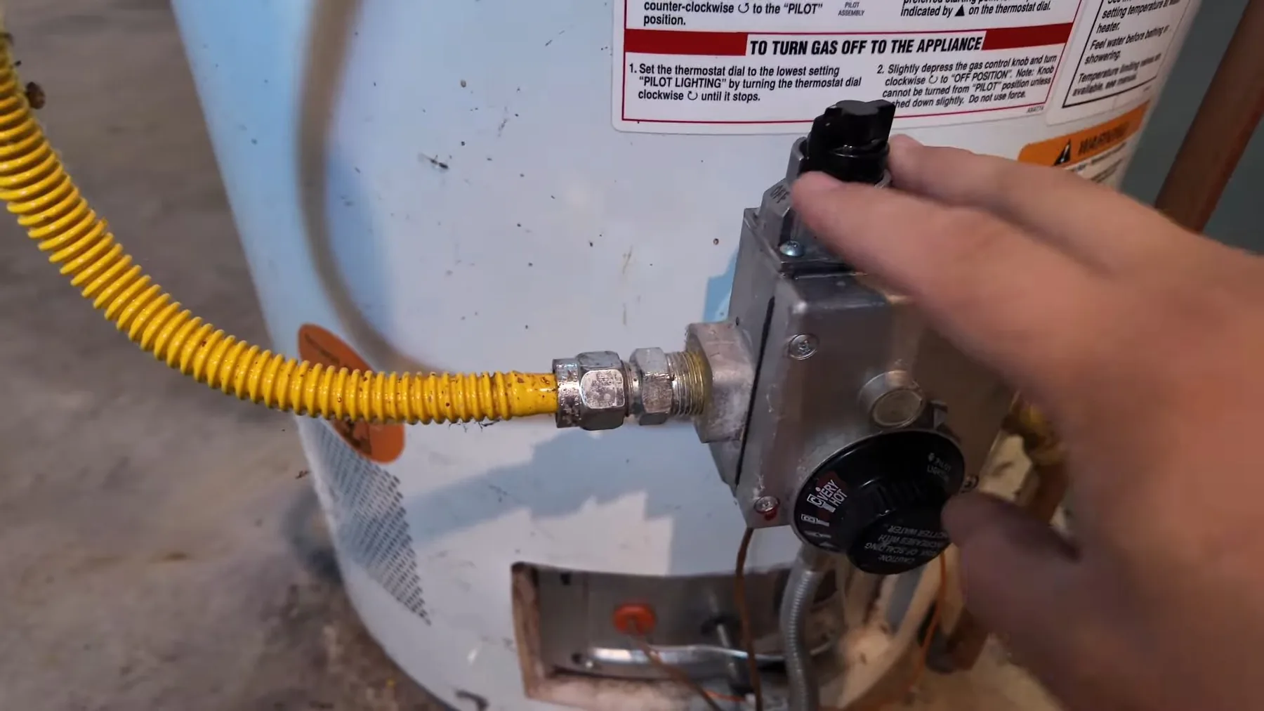 Technician turning a gas valve on a water heater during service