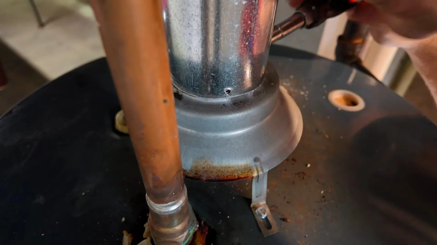 Vent pipe being fitted during a water heater installation
