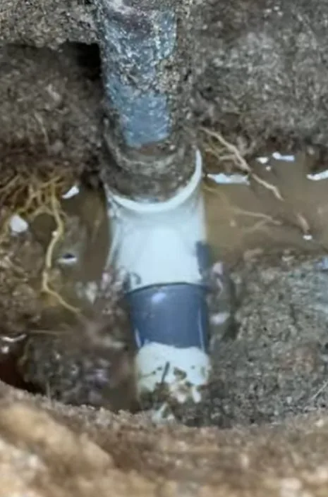 Water leak visible beneath an opened section of concrete slab